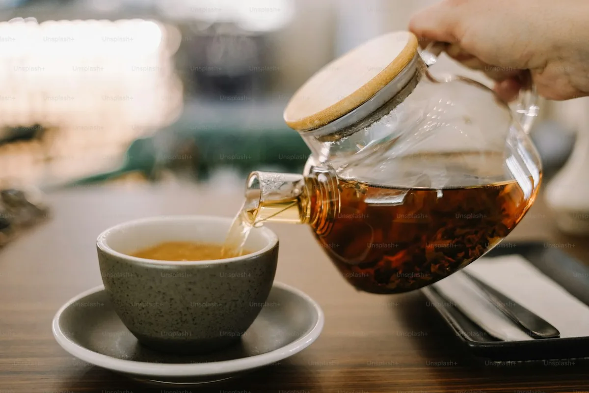 A glass of black tea being poured